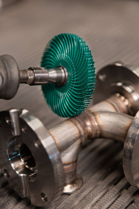 Green Spindle Mounted Bristle Brush being used to clean a metal fixing